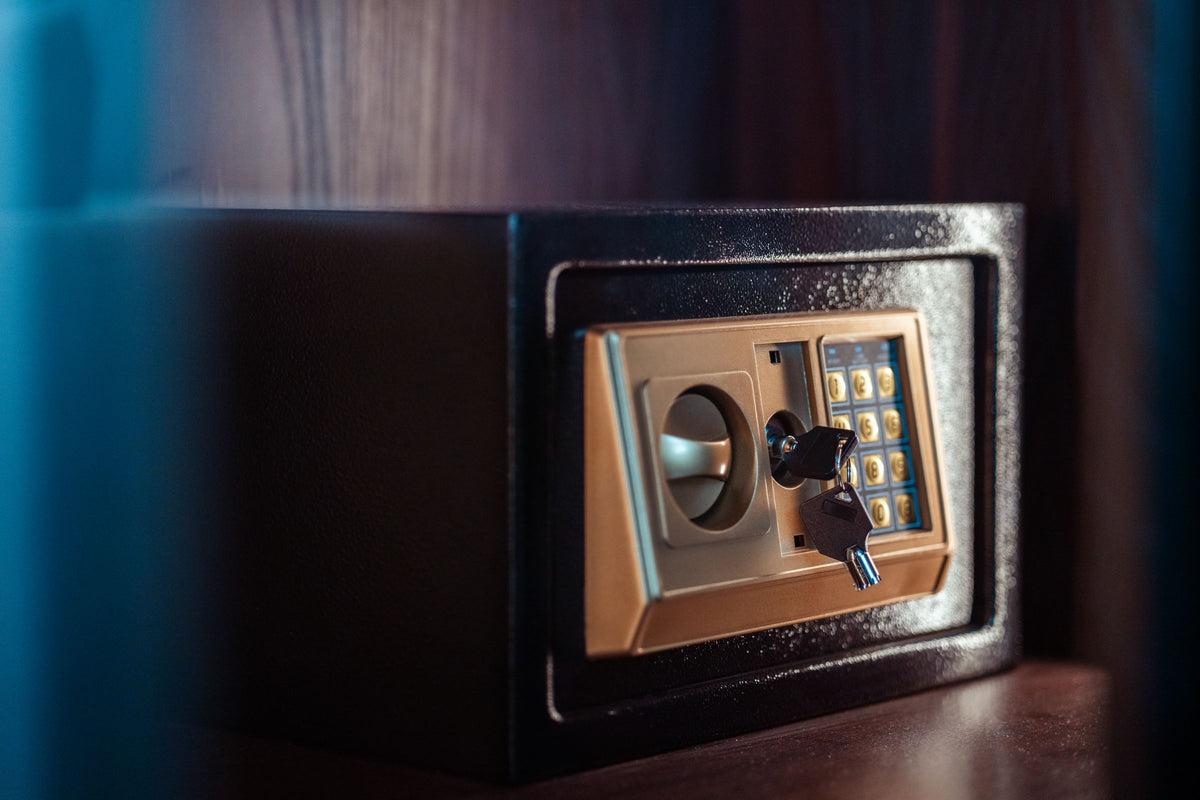Small electronic safe with a key in a dark cabinet
