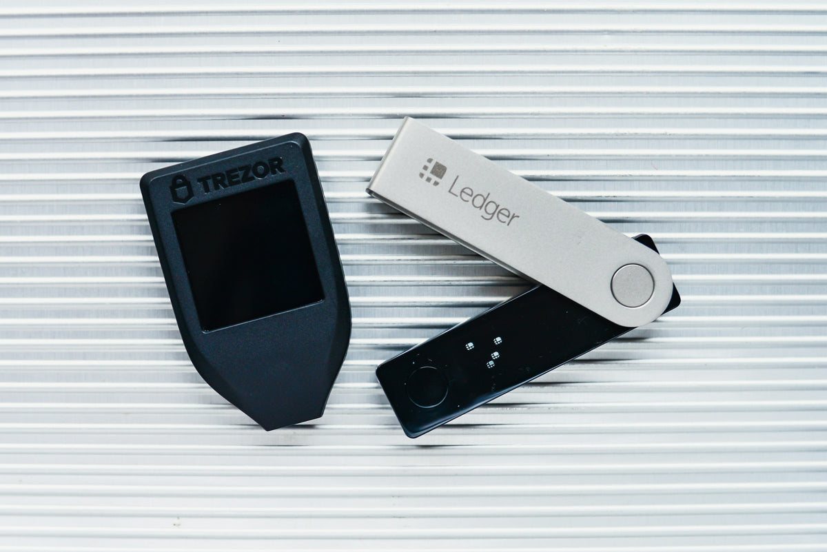 Two crypto hardware wallets on a white surface